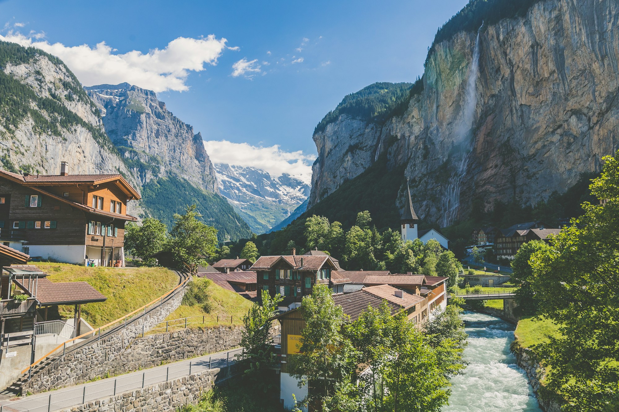 Chalets and a waterfall beneath the towering cliffs of Lauterbrunnen
